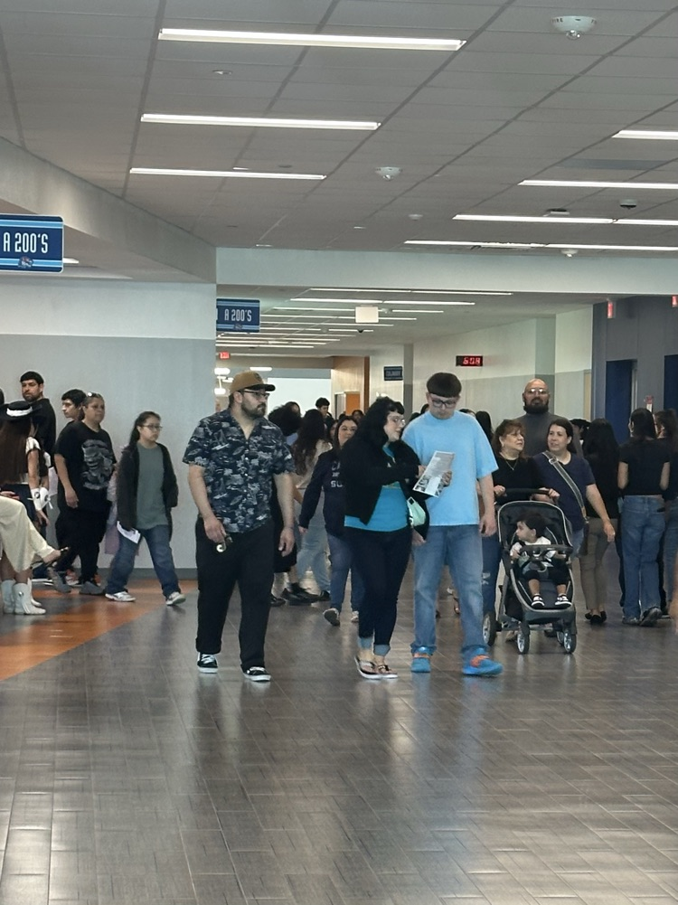 Students walk through a crowded high school hallway during Tiger Cub Camp, talking and smiling as they explore campus.