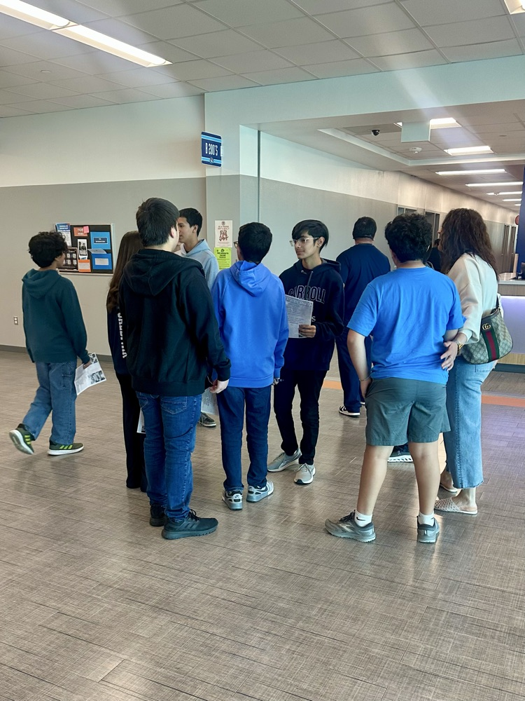 Students walk through a crowded high school hallway during Tiger Cub Camp, talking and smiling as they explore campus.