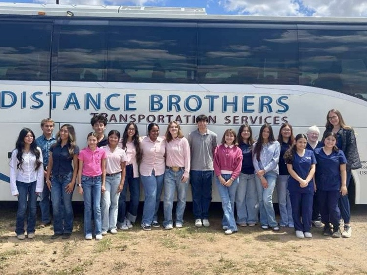 Alt text: FFA students posing in front of a bus after competing at Coastal Bend District CDEs.