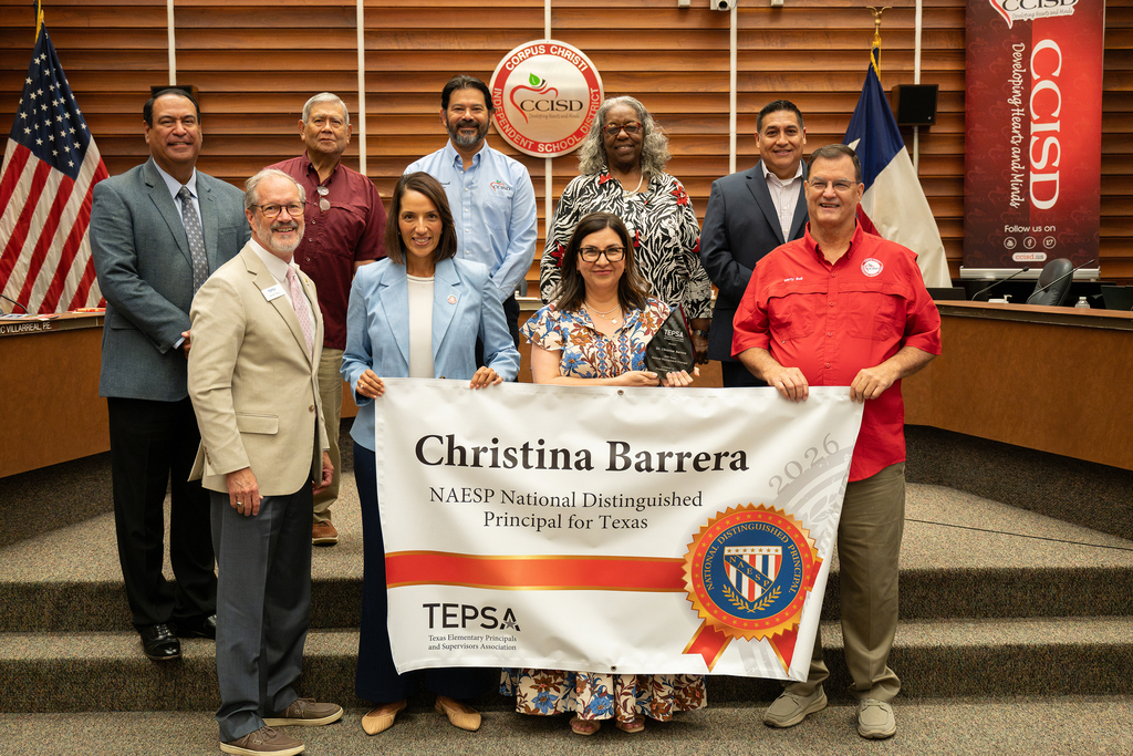 A group of people stand on steps holding a banner reading "Christina Barrera" and "NAESP National Distinguished Principal for Texas".