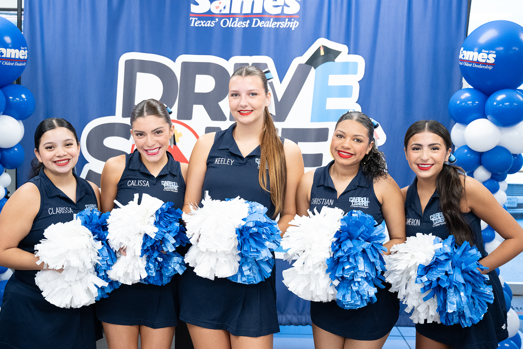Five cheerleaders in blue uniforms with pom-poms, standing in front of a blue banner with "Drive" and balloons.