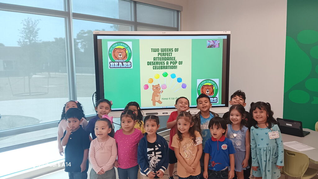 Group of children standing together in front of a screen with a presentation about bears.