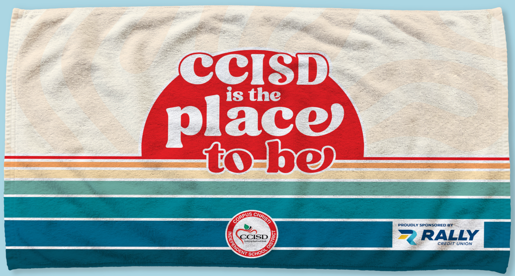 A white towel with a blue, green, and blue striped border. Centered is a red circle saying "CCISD is the place to be".