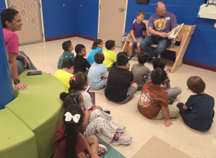 Watchdog Mr. Meader captivates Mrs. Patacsil's first grade with a read aloud.  A perk of being a Watchdog.