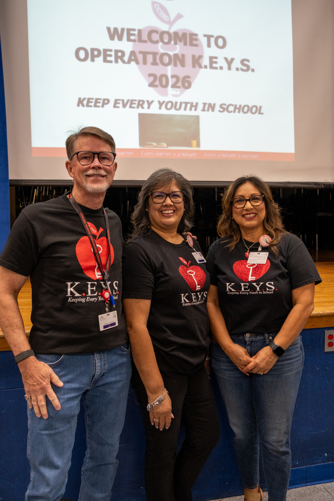 Three people pose for a photo in front of a presentation screen. It reads "Welcome to Operation K.E.Y.S. 2026."