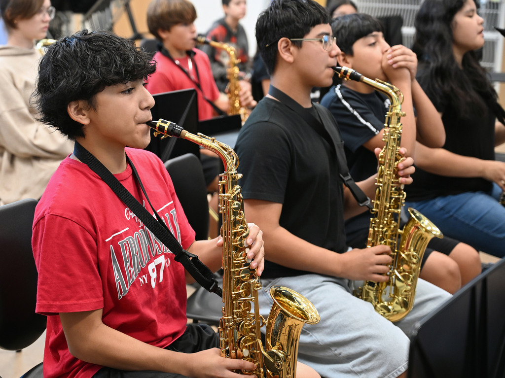 Students play the saxophone. 