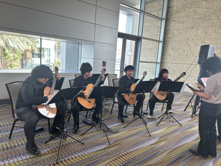 guitar students playing for visitors as they arrive