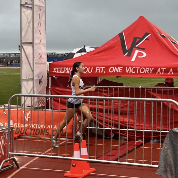 Person running past barrier near red tent with VP logo, two orange traffic cones.