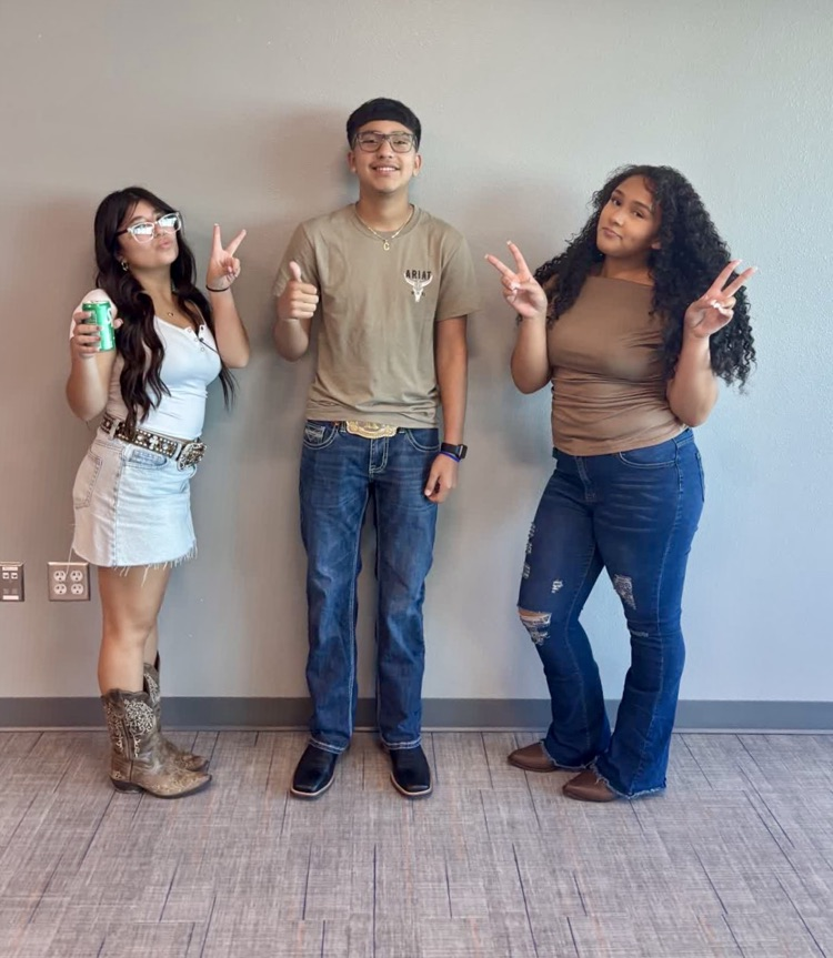 Three teens, two girls and one boy, posing with hands in front of a white wall.