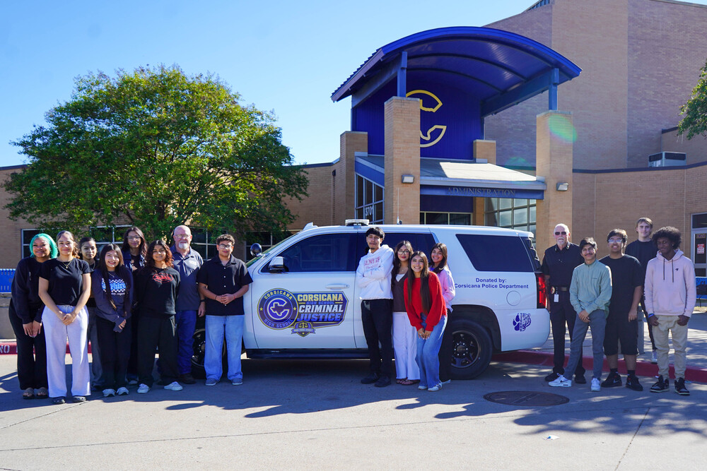 Corsicana High School students and criminal justice teacher Mark Mahone posing beside the donated 2020 Chevy Tahoe from The Corsicana Police Department