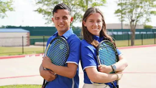 Higgs Twins smiling with tennis rackets