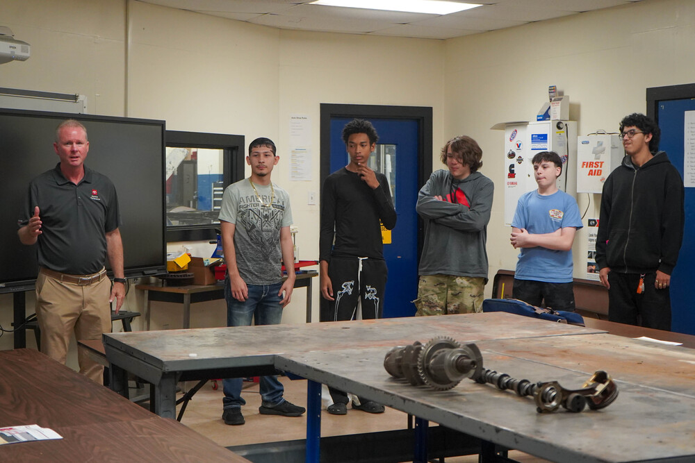 Photograph shows an instructor and CHS students gathered in a workshop
