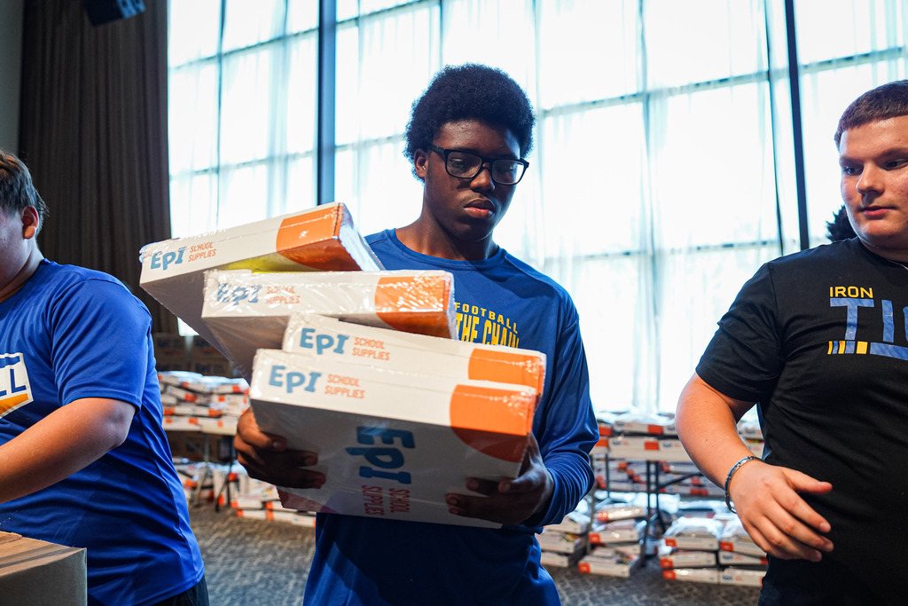 student helping with supplies