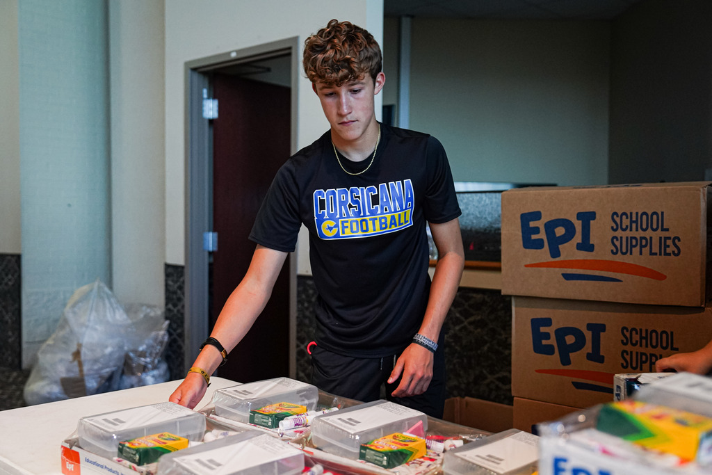 student helping with supplies