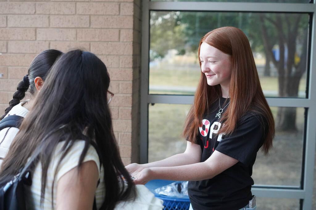 A student from the Hope Squad passes out stickers on You Matter Day at Corsicana High School