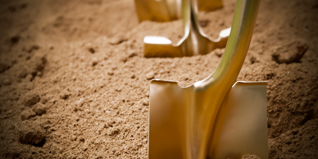 Shovels partially embedded in loose brown soil