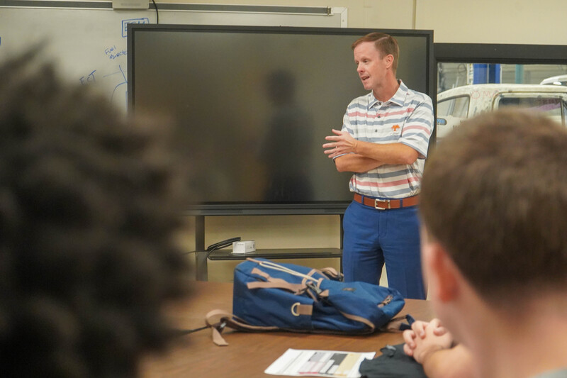 Photograph shows an instructor and CHS students gathered in a workshop