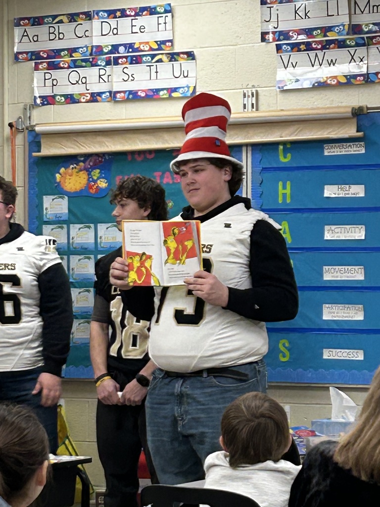 Football players reading to students