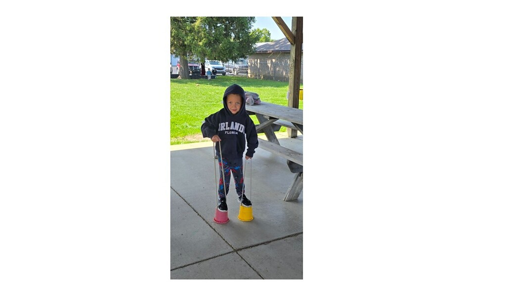 Boy on walking cups outside playing