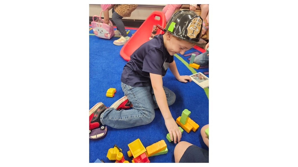 Playing playing with a fireman hat on.