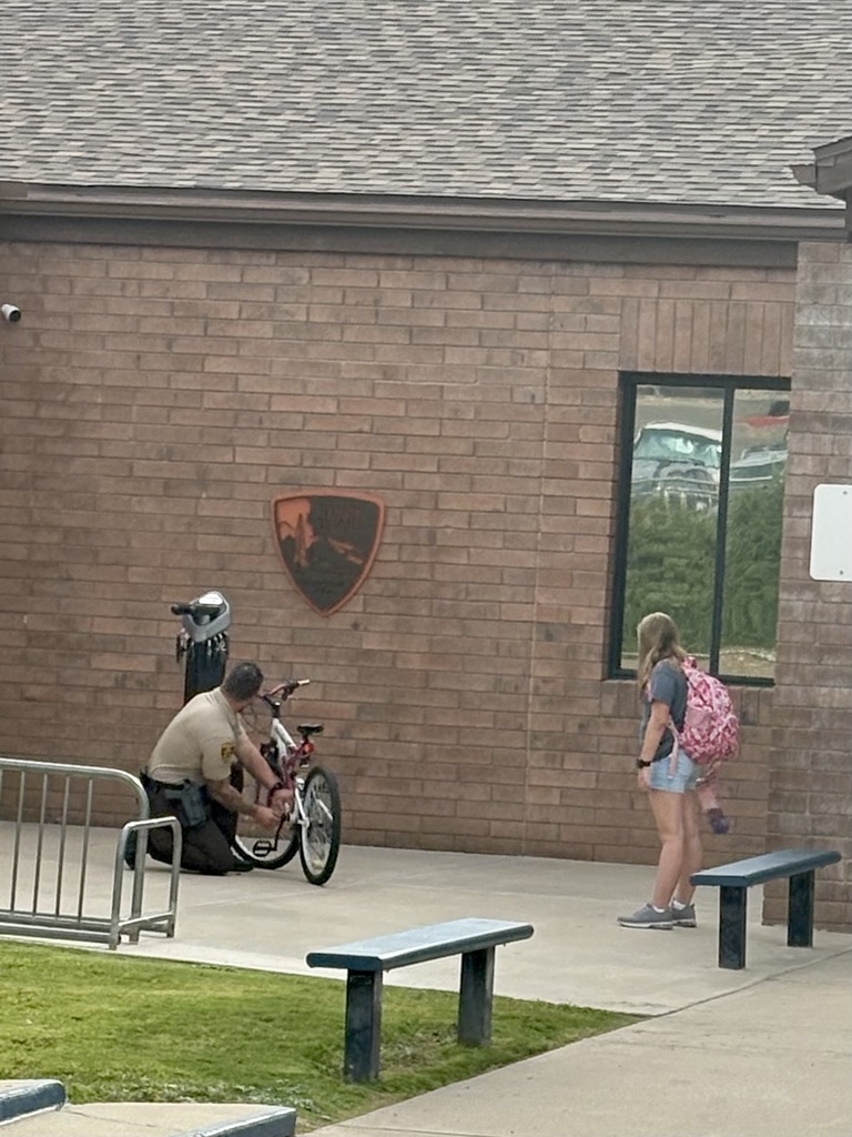 Deputy Hawkins and one of our fabulous custodians Justin, helping fix a students bike.