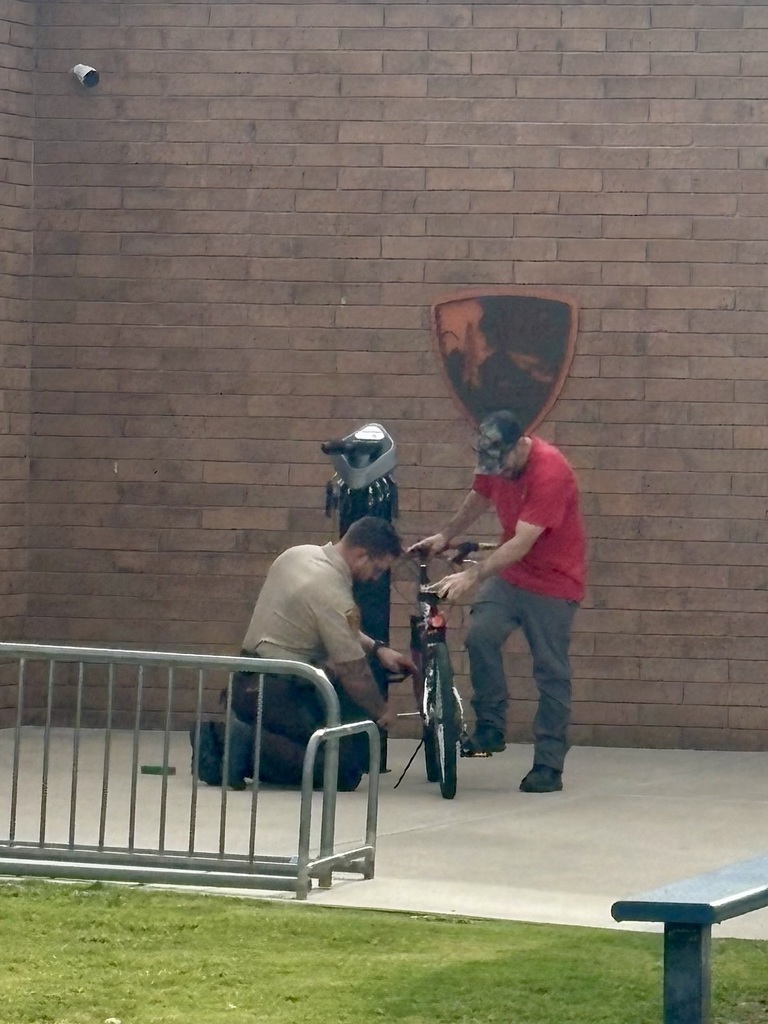 Deputy Hawkins and one of our fabulous custodians Justin, helping fix a students bike.
