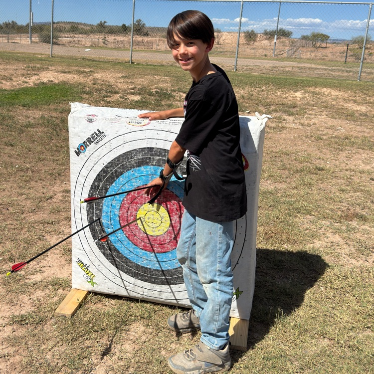 student number 2 standing by a target showing his great shot.