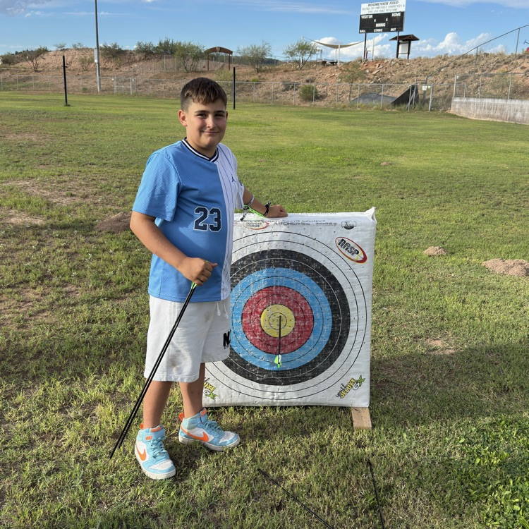 boy standing next to bullseye