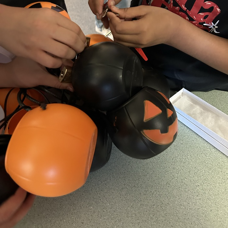 black and orange pumpkins locked together, kids trying to get undone 