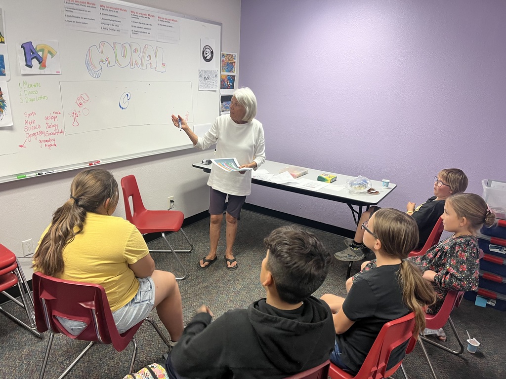Kiddos giving Mrs. Joan their ideas for painting the next mural.