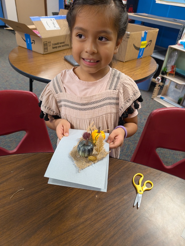Student with her adorable miniature pumpkin project.