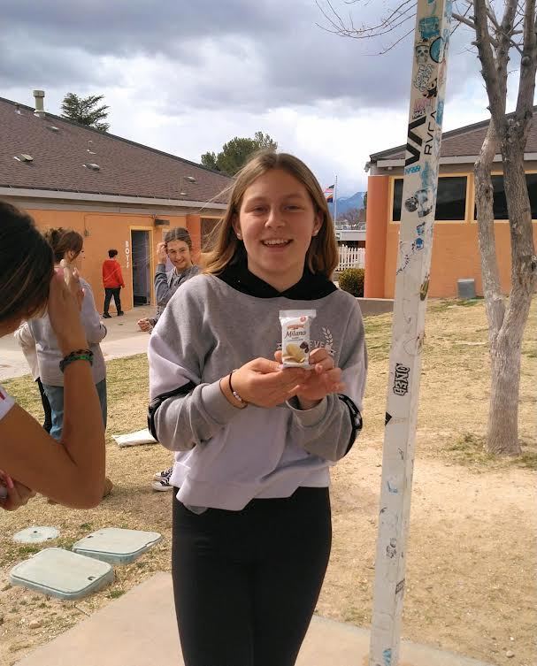 Smiling female student showing an almond package