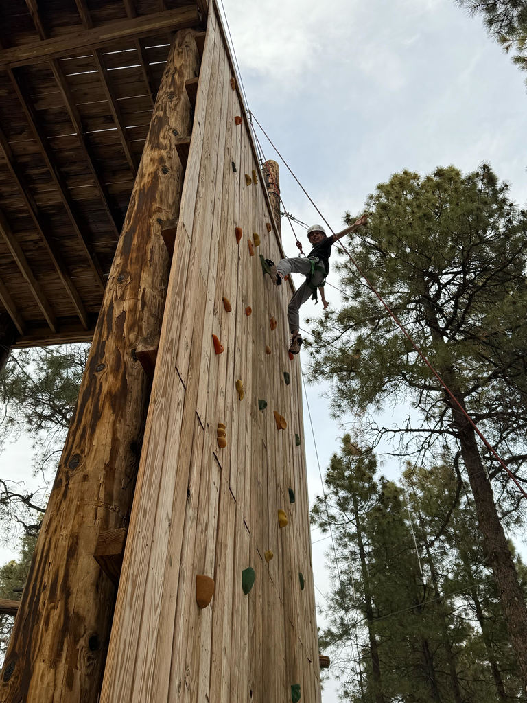 student climbing a climbing wall
