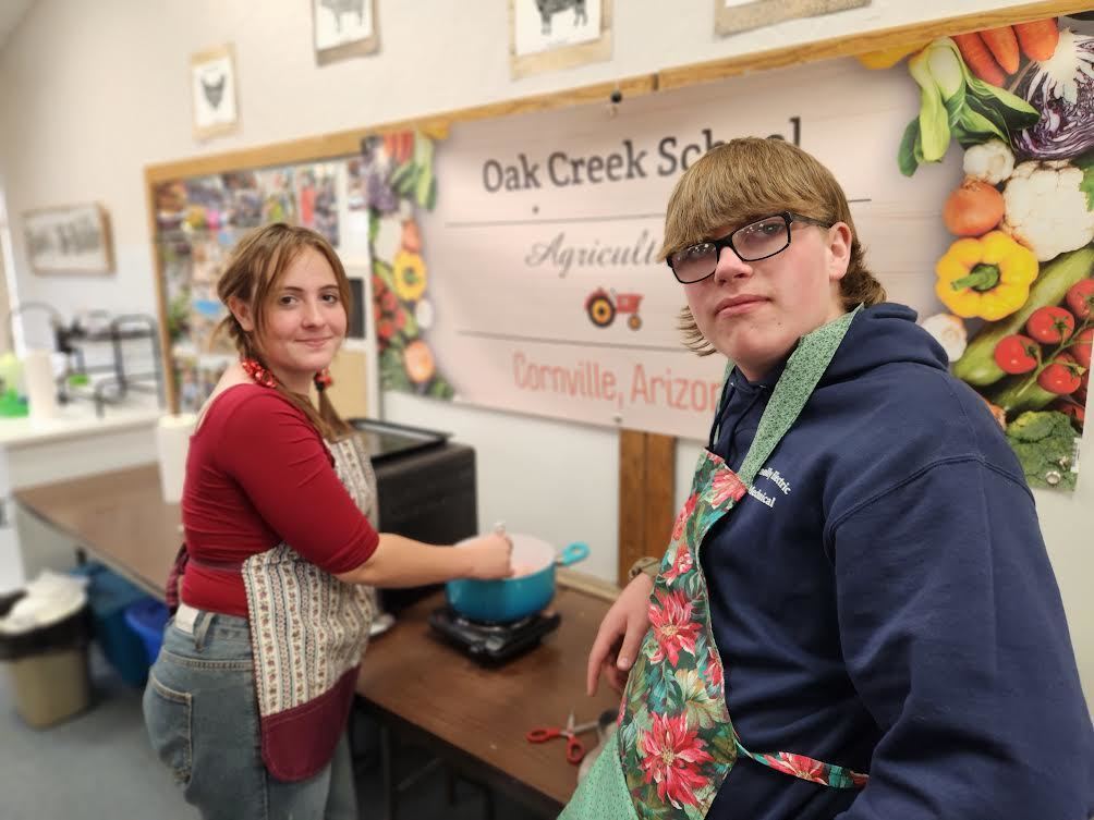 Two students cooking on hot plate