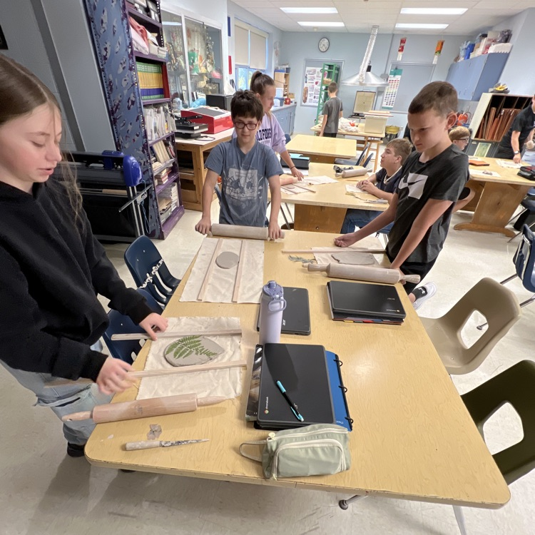 students working at their table with clay.