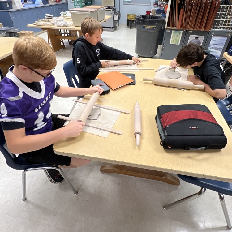 students working on their projects at their table.