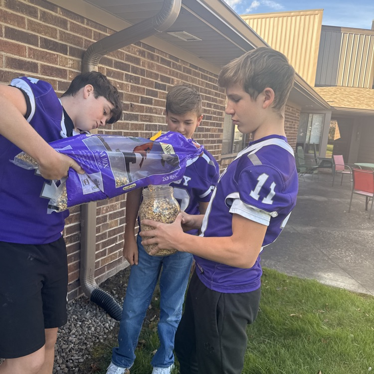 football players filling birdfeeders