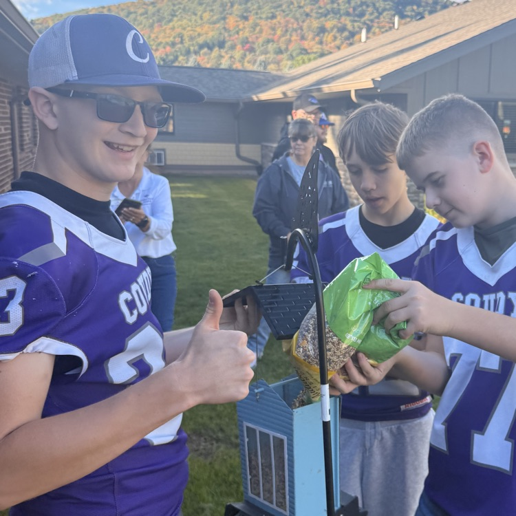 Junior High football players filling birdfeeders