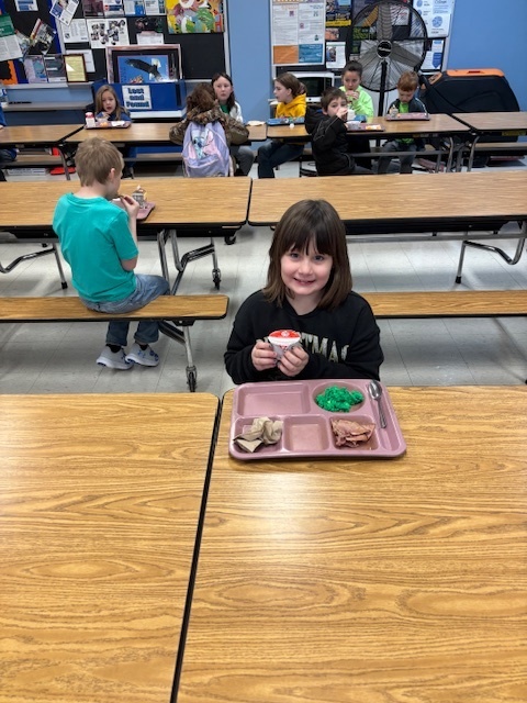 Elementary students enjoying green eggs and ham.