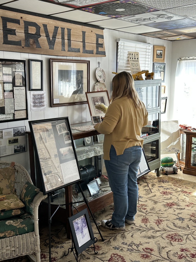 A student takes on the spring cleaning in the front room of the museum.