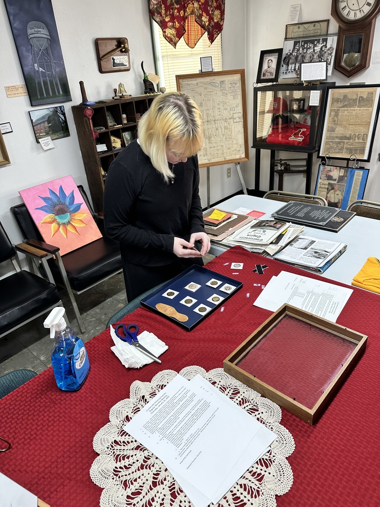 A student rearranges a display at the museum.