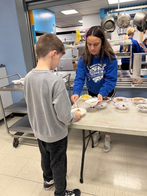 Aaliese helping students with the toppings.