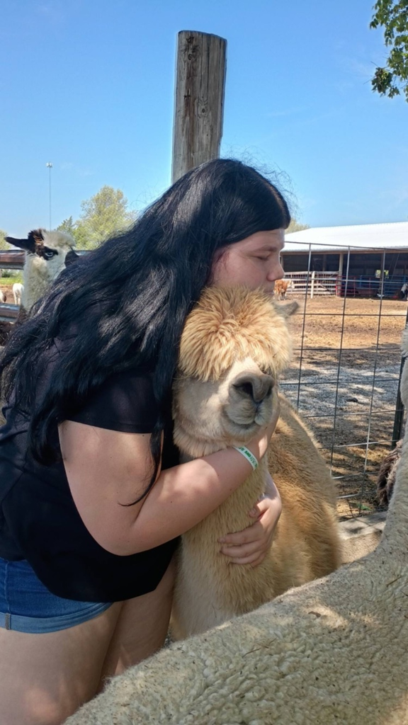 Emma hugging an alpaca