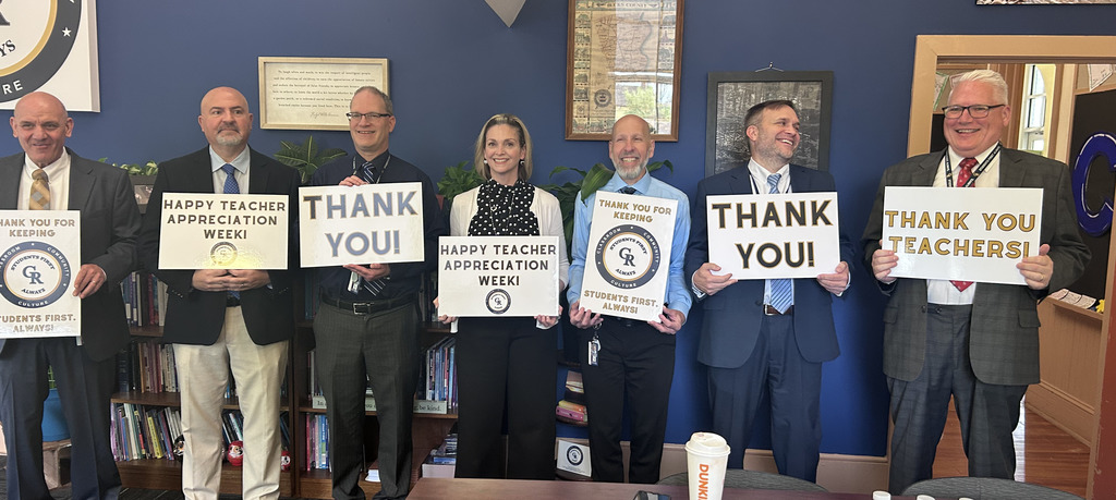 Adminstration staff holding signs that say thank you to teachers!