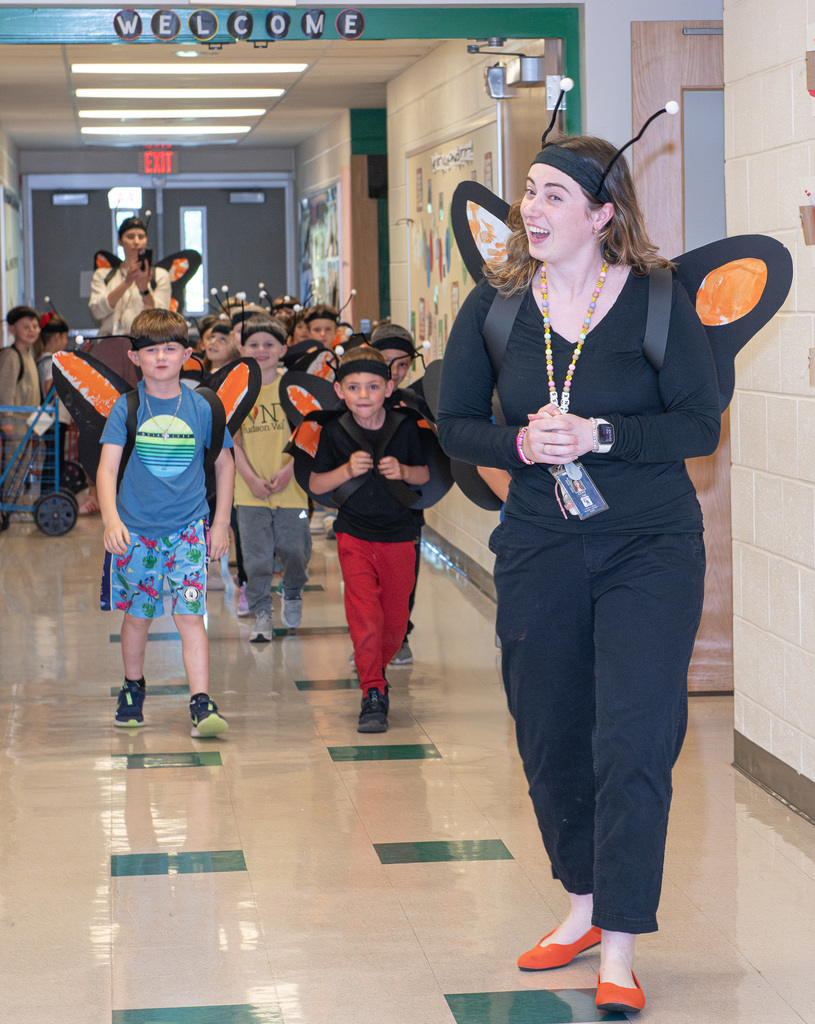 Students walking down the hall to release butterflies with a teacher