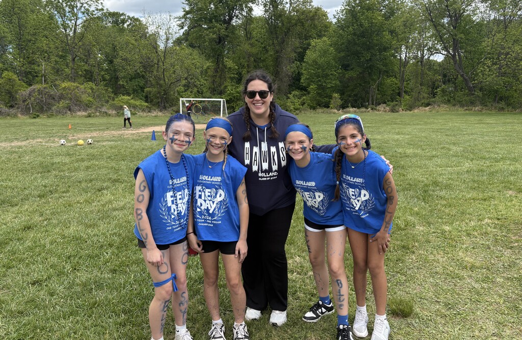 students smiling with their teacher for fieldday