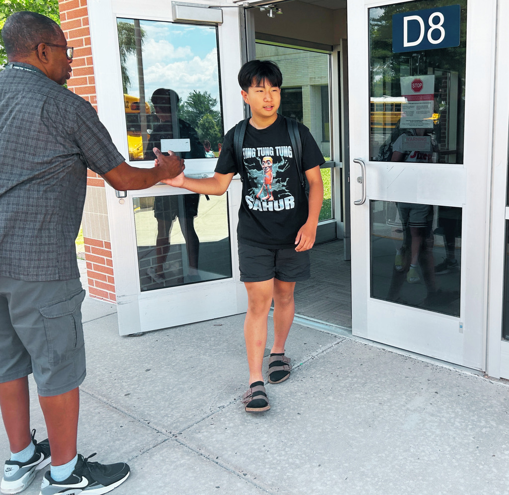 student shaking hands with his teacher for last day