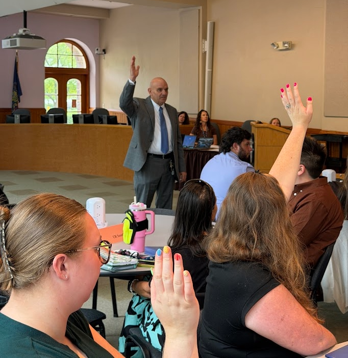Doctor Sanko with new teachers raising their hands