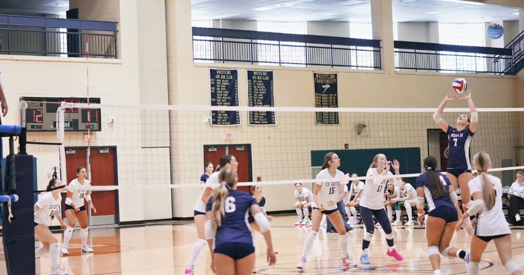 group of volley ball players with one player setting the ball for teammate