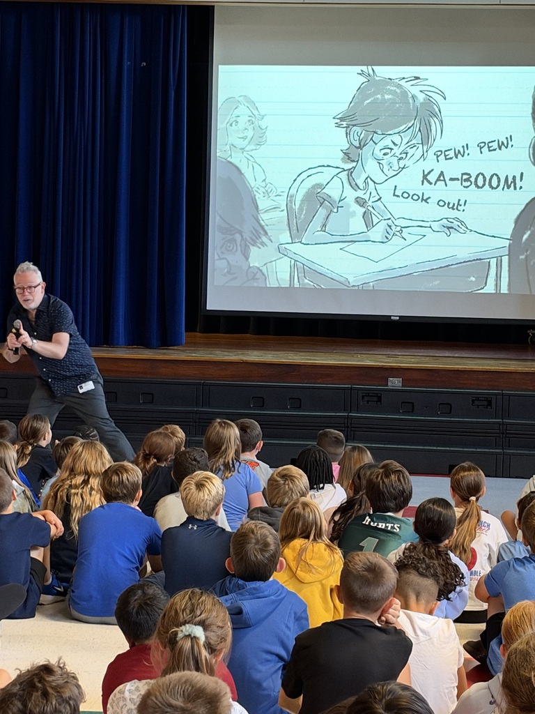 author showing his work and explaing to a group of kids what being an author means